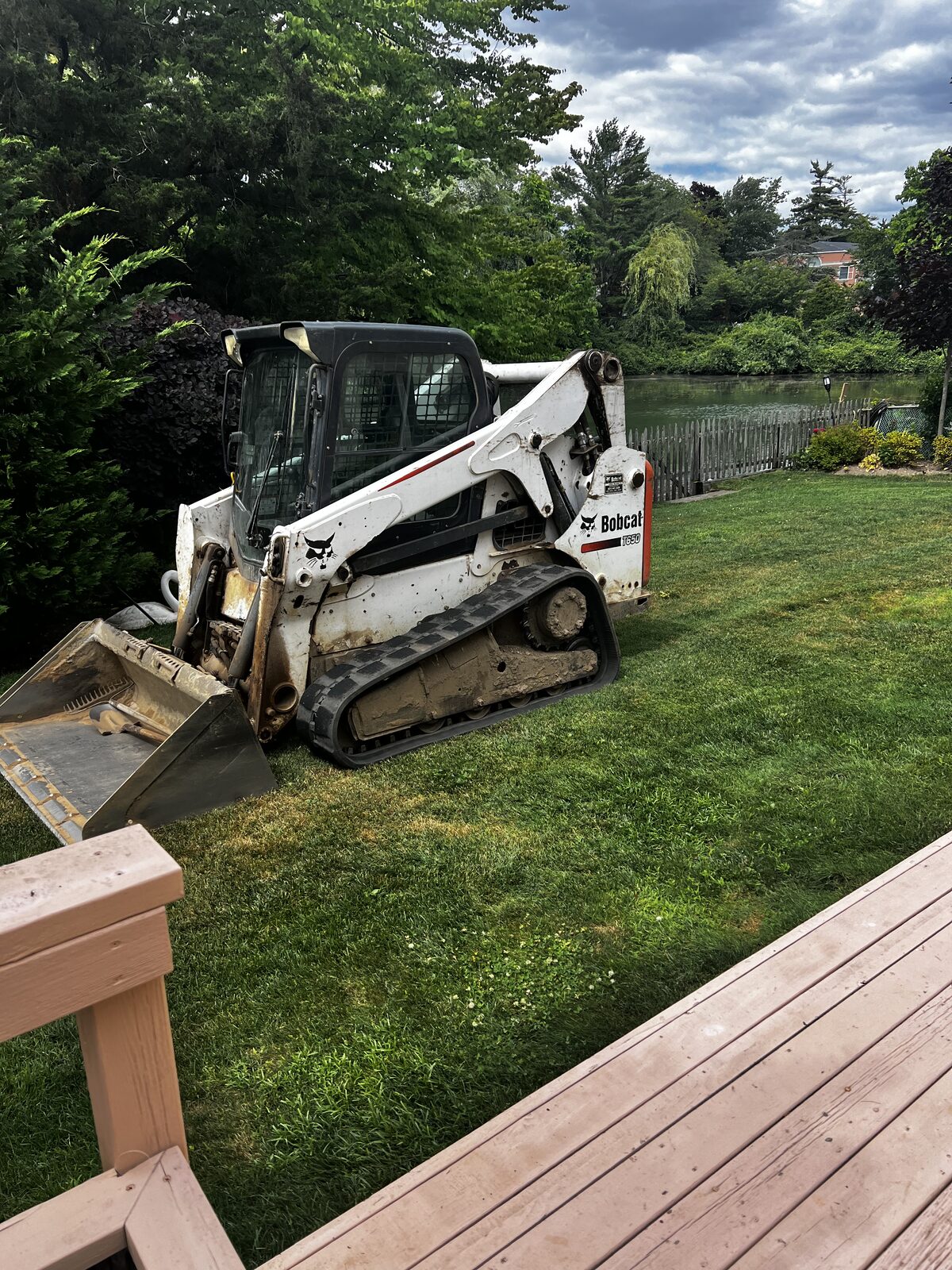 Compact loader regrading a backyard lawn